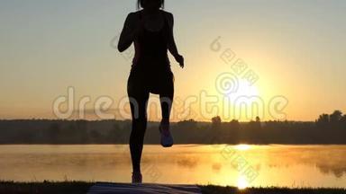 夕阳西下，女人在<strong>湖岸</strong>一处奔跑